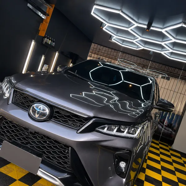 SUV cinza com pintura impecável sob a iluminação do lava jato OLJ