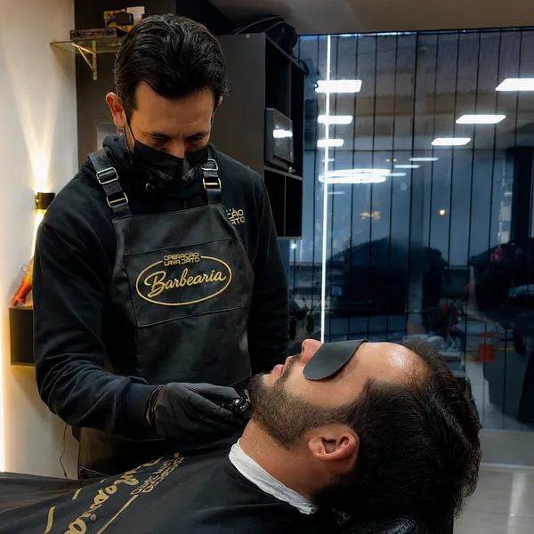 Barbeiro da OLJ finalizando a barba de um cliente