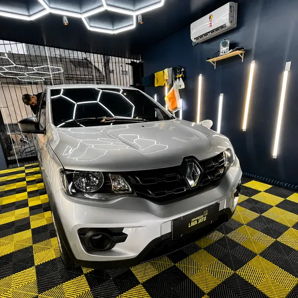 Carro compacto prata recém lavado no piso xadrez amarelo e preto da OLJ