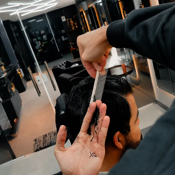 Detalhe do corte na tesoura e pente na barbearia da OLJ